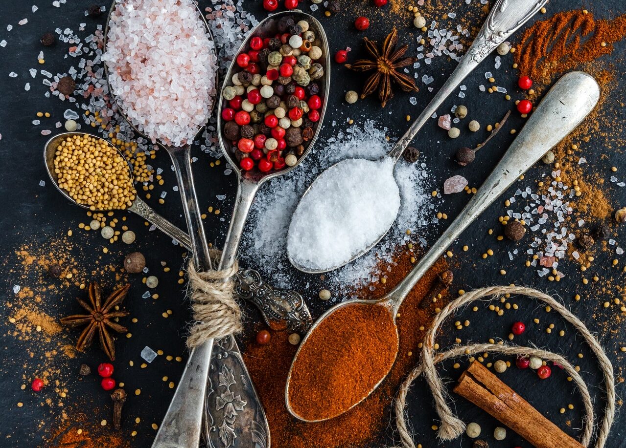 assortment of spices and herbs on dark grey background