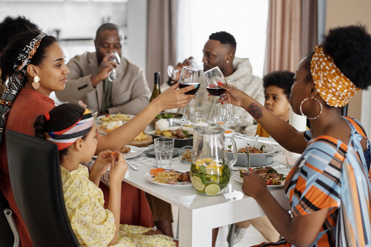 African American family sitting down at table having dinner together and celebrating