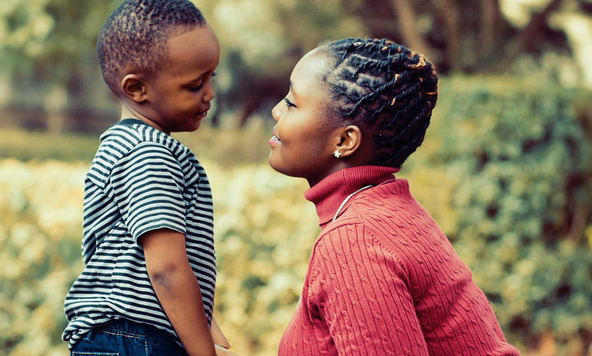 Black mom squatting, parenting her son