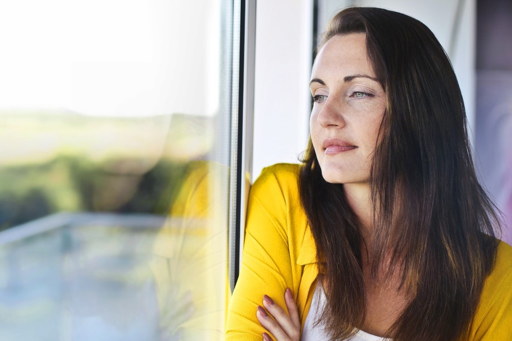 White woman with browh hair wearing yellow cardigan trying not to make a comparison with herself.