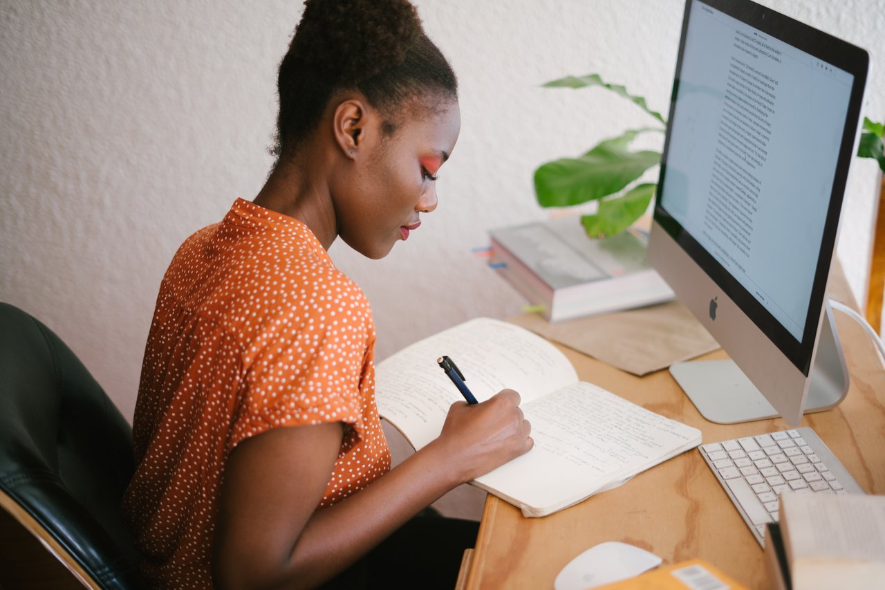 Black woman working at desk to discover her core value.