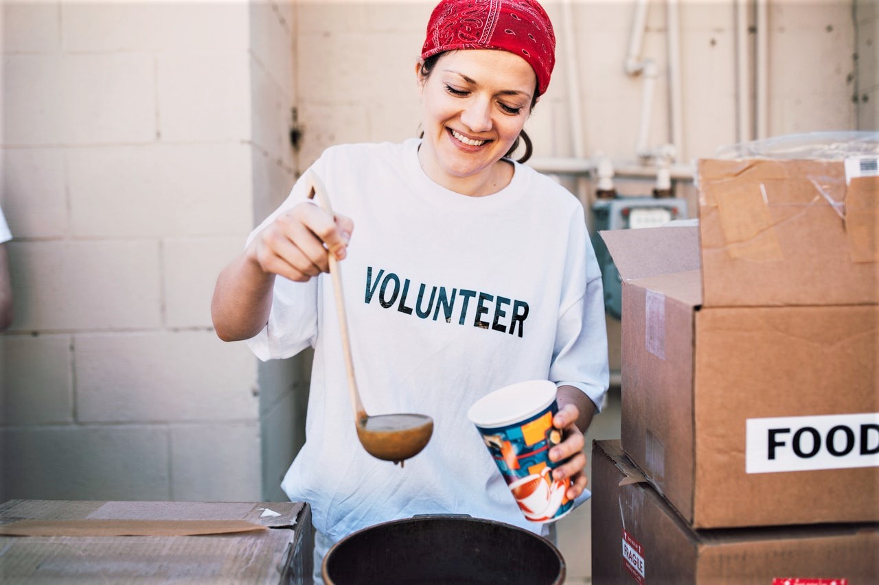 Woman pouring soup as a volunteer to be nice