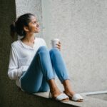 Young North American Indian woman holding a cup of coffee full of joy.