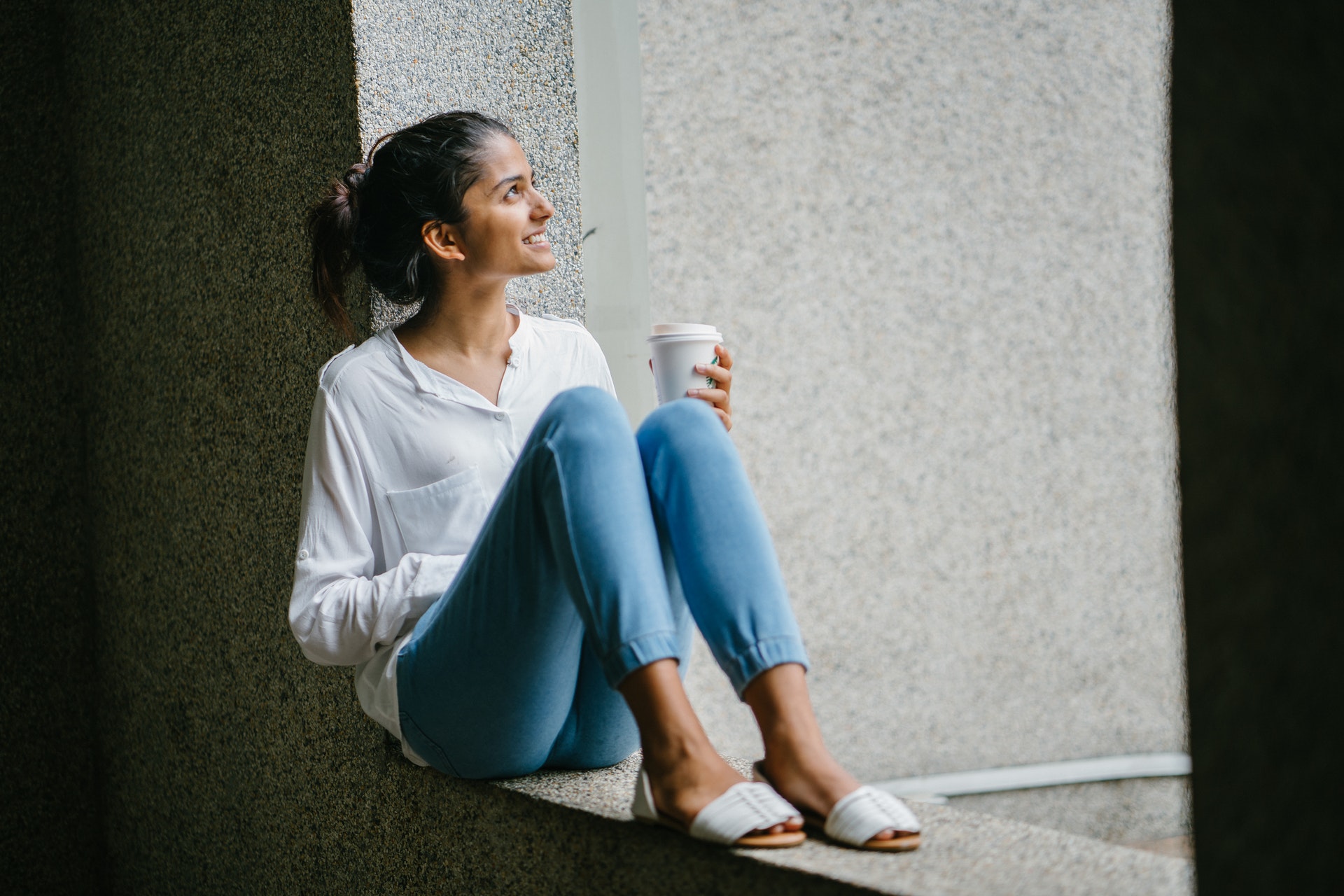 Young North American Indian woman holding a cup of coffee full of joy.