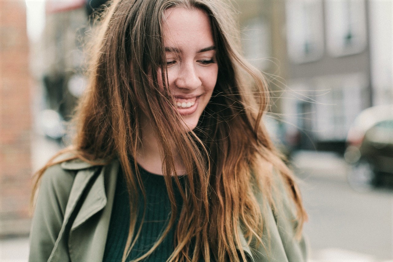 Young White woman with brunette hair smiling with joy.