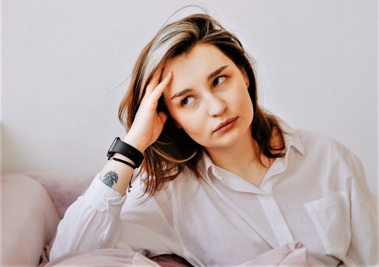 White young woman sitting on couch upset and not looking patient