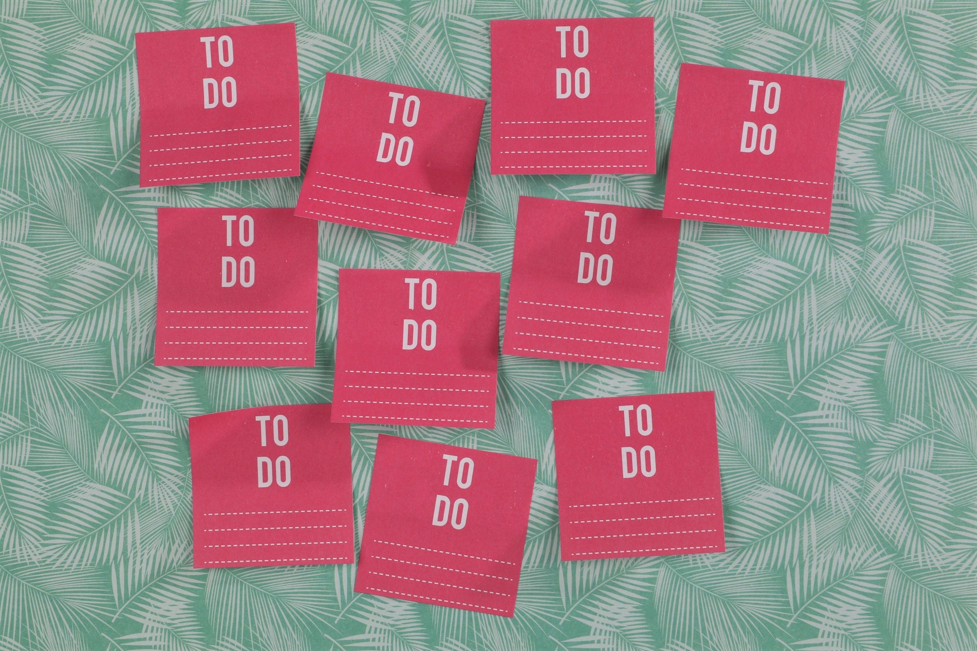 Procrastinating with multiple pink to do list post it notes.